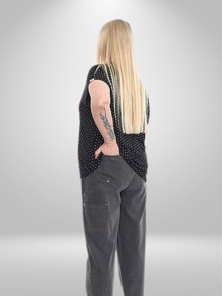 A plus-size model wearing a black polka dot blouse (sizes 20-26), featuring a V-neckline and breathable lightweight fabric, paired with grey trousers.