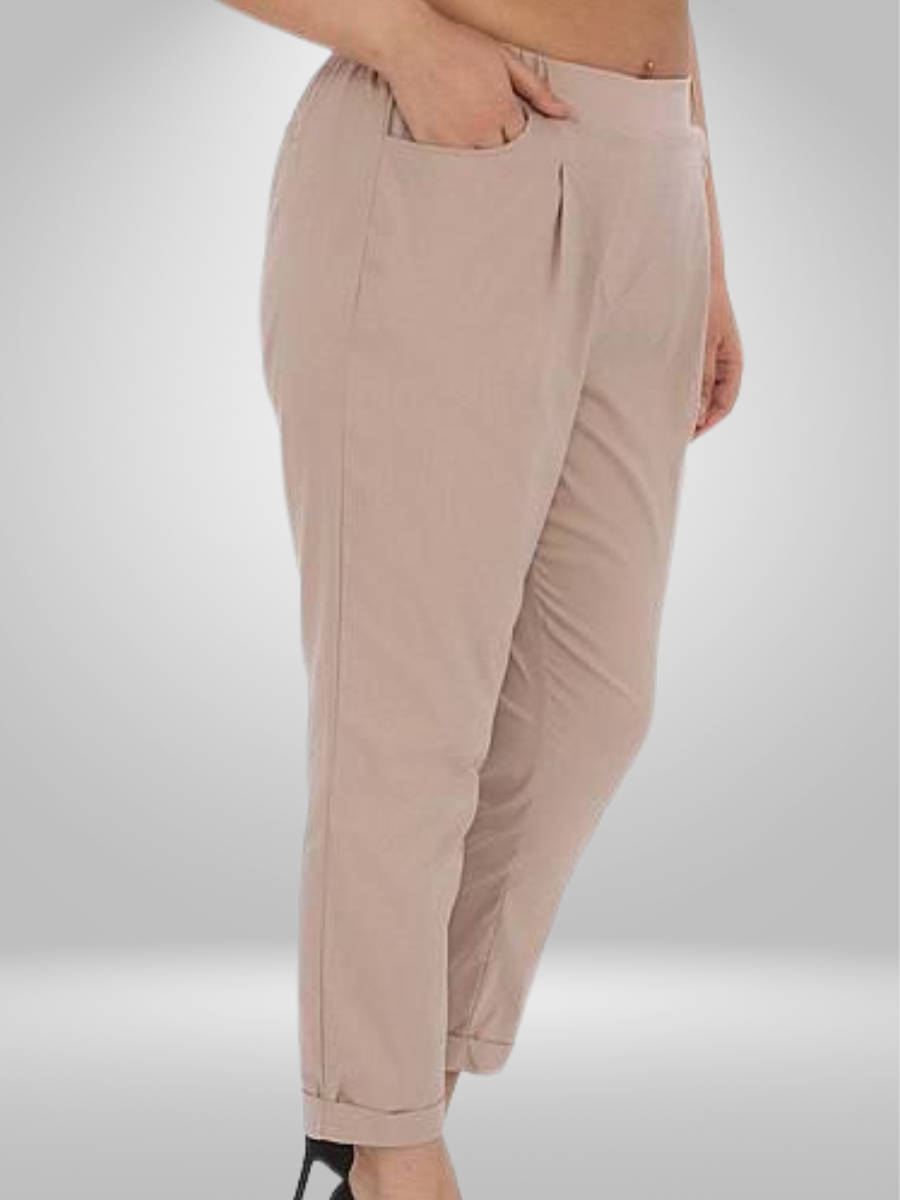 A plus-size model wearing a black sleeveless tank top and grey joggers with an abstract black print (sizes 18-24), paired with black sneakers.